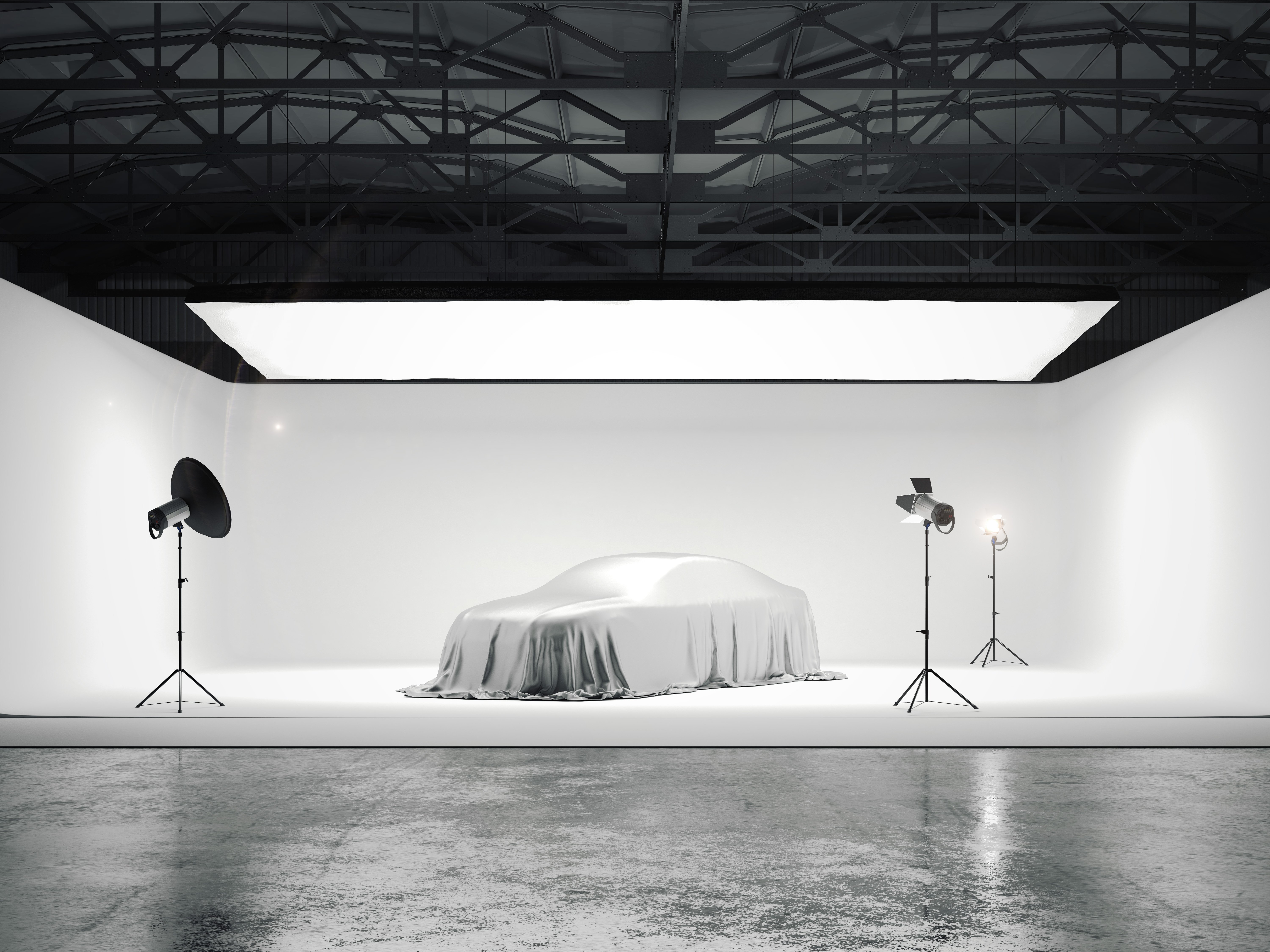 Grande estúdio fotográfico com carro e várias fontes de luz